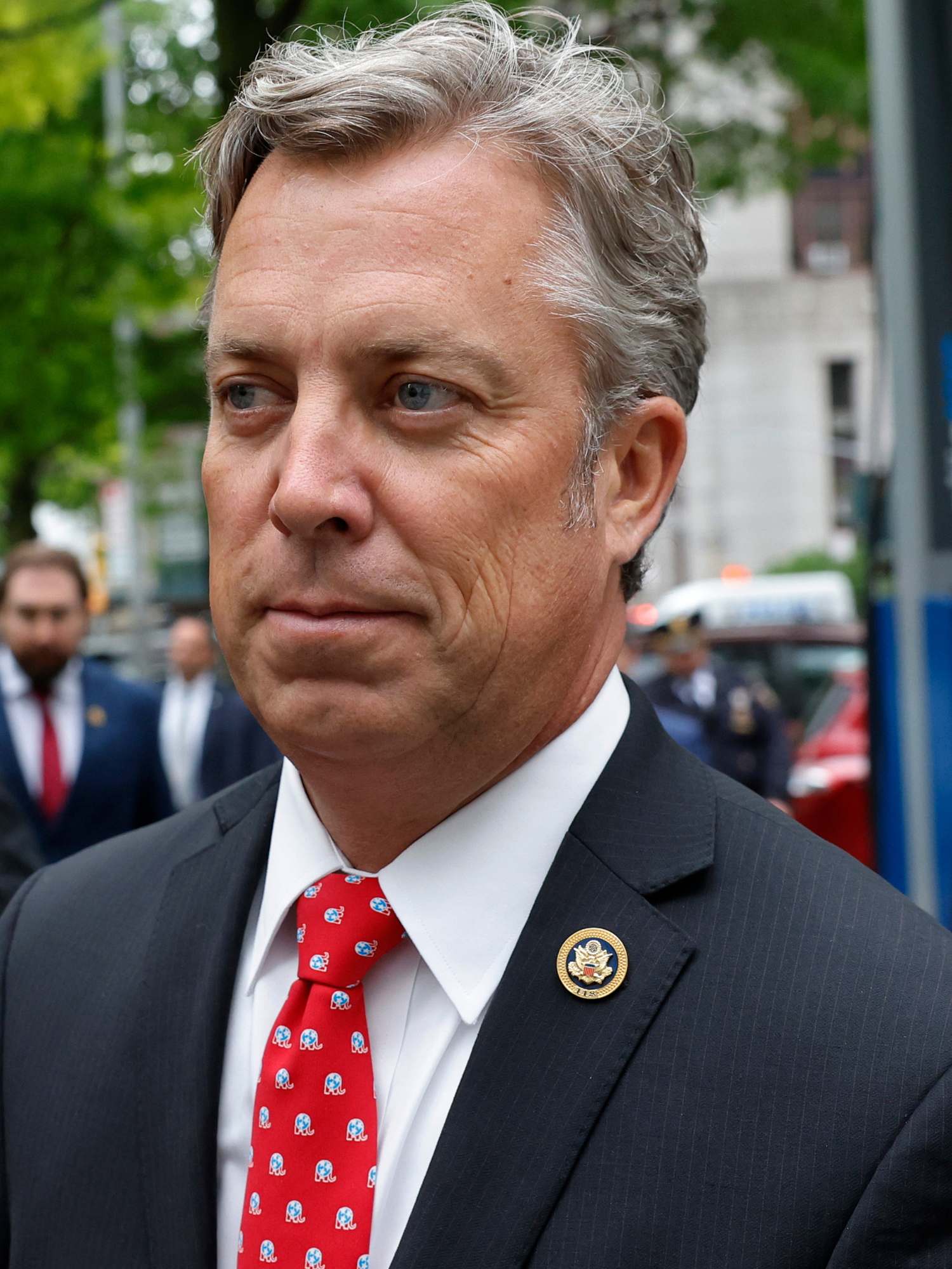 Andy Ogles, a white man with short grey hair, a black suit and patterned red tie.