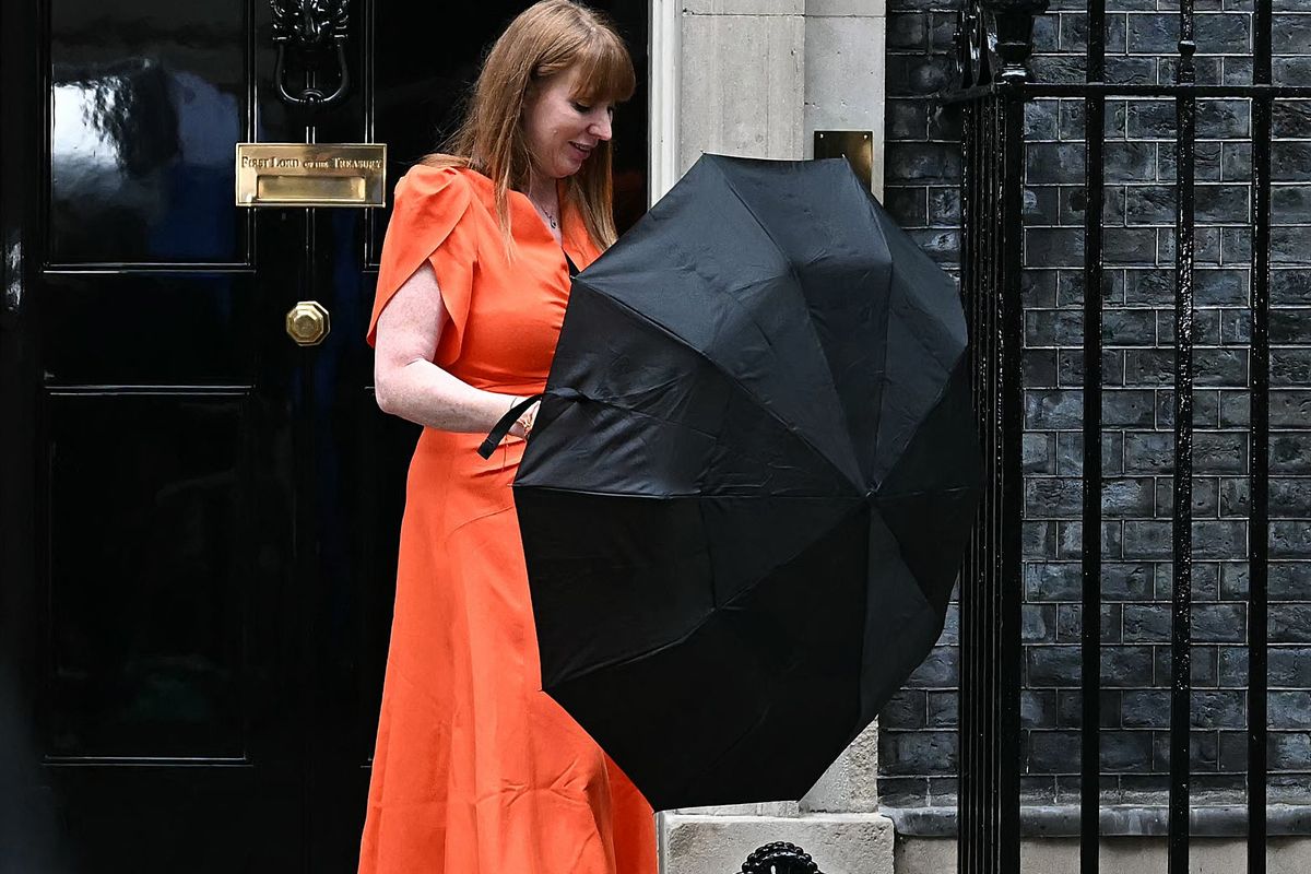 Angela Rayner leaves Downing Street in the rain holding an umbrella and wearing an orange dress