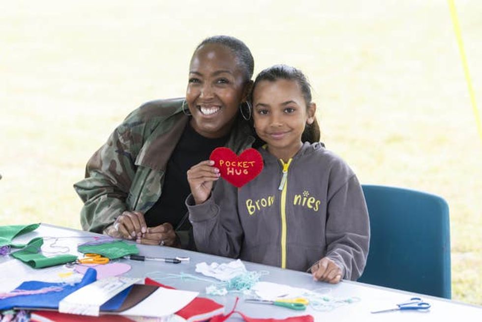 Angellica Bell smiling alongside a Brownie in uniform