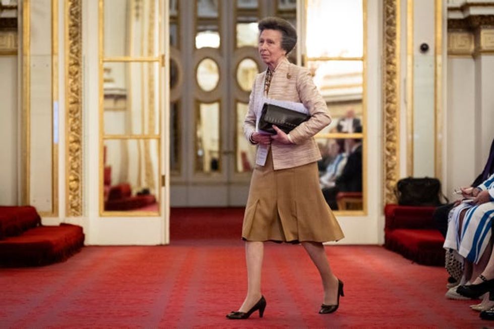 Anne holding notes and her handbag as she walks into the ballroom at Buckingham Palace