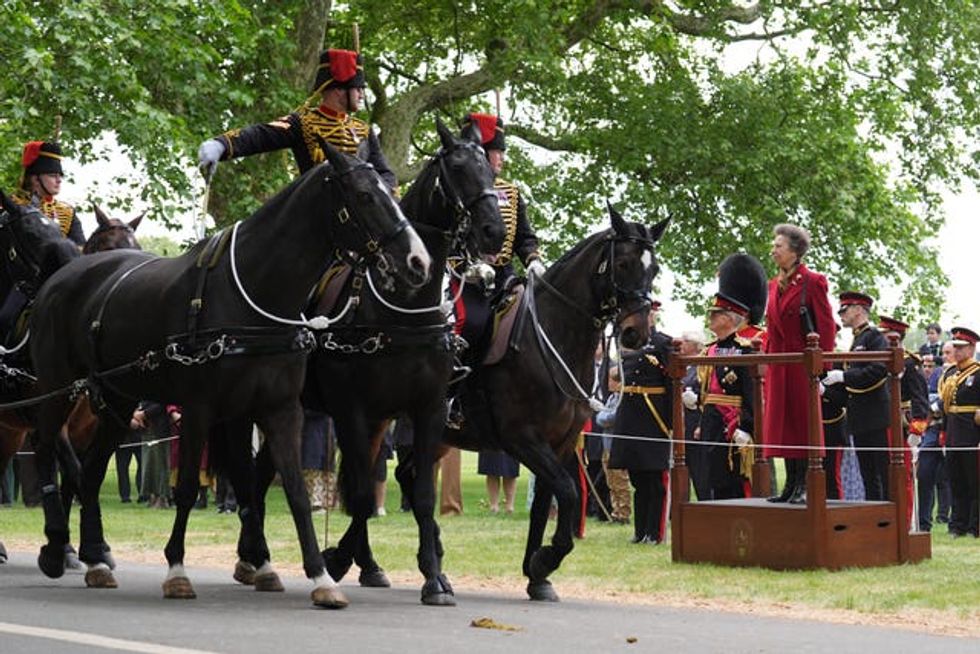 Anne stands on a small dais to inspect members of the King\u2019s Troop Royal Horse Artillery