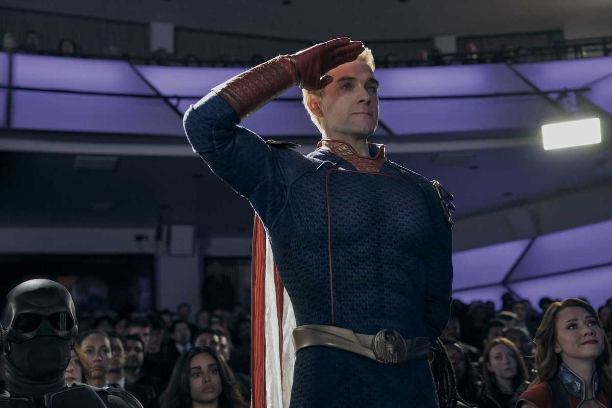 Antony Starr as Homelander in The Boys, standing and saluting something off-camera.