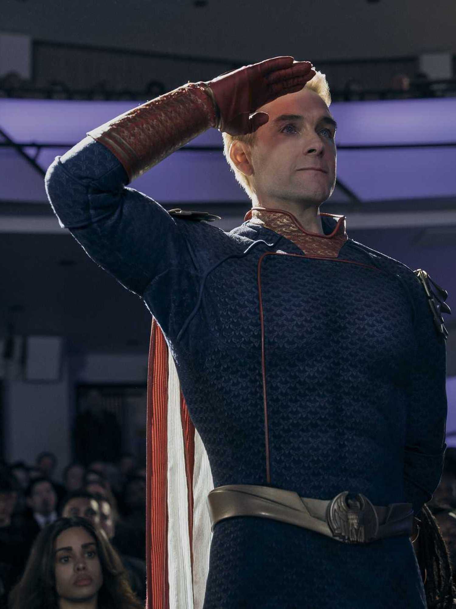 Antony Starr as Homelander in The Boys, standing and saluting something off-camera.
