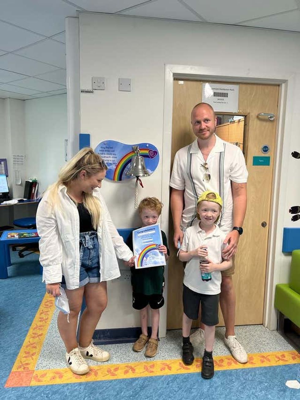 Archie Wilks with his mother Harriet, father Simon and twin brother Henry, ringing the bell at Addenbrooke\u2019s Hospital, Cambridge, to celebrate the end of his treatment for the rare childhood cancer neuroblastoma