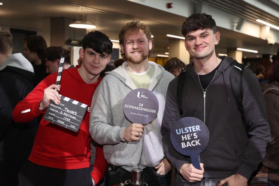 Arnold Schwarzenegger fans hold plaques ahead of a ceremony presenting him with an honorary doctorate at Ulster University in Belfast