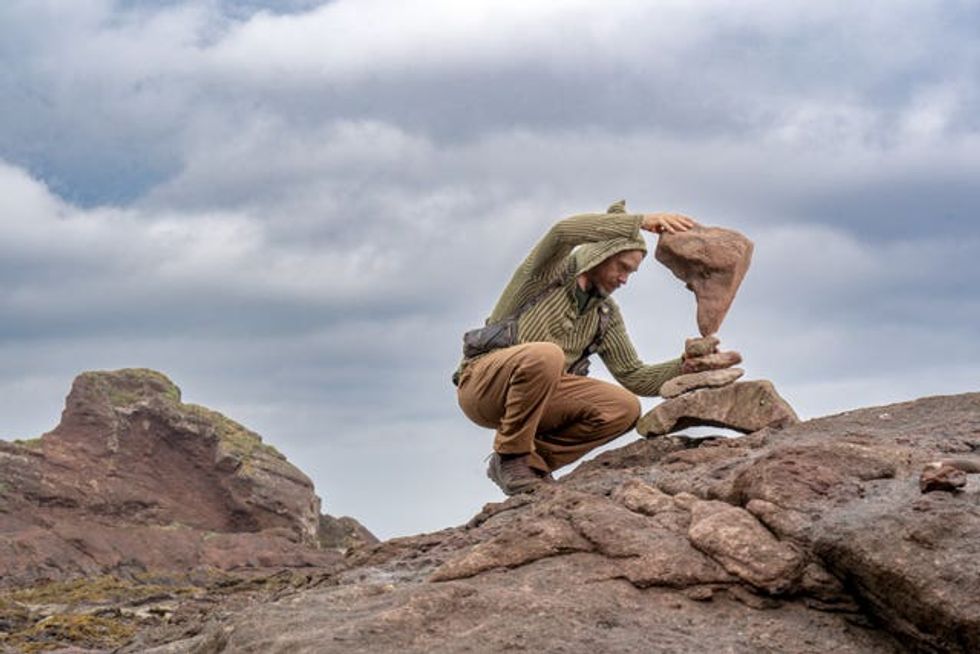 Artist Michael Grab balancing rocks on Bayswell Beach in Dunbar