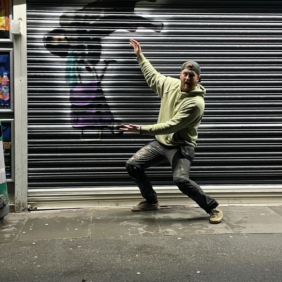 Artist Tee2Sugars poses with his artwork