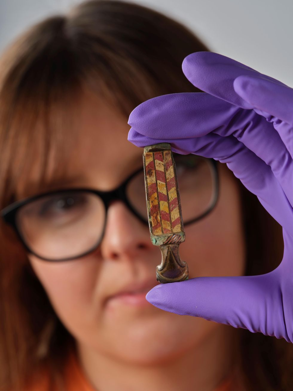 Assistant Curator Bethany Simpson with the brooch