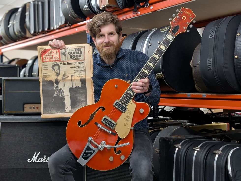Auctioneer Luke Hobbs with the Jimmy Page guitar and a copy of the NME magazine (Gardiner Houlgate/PA)