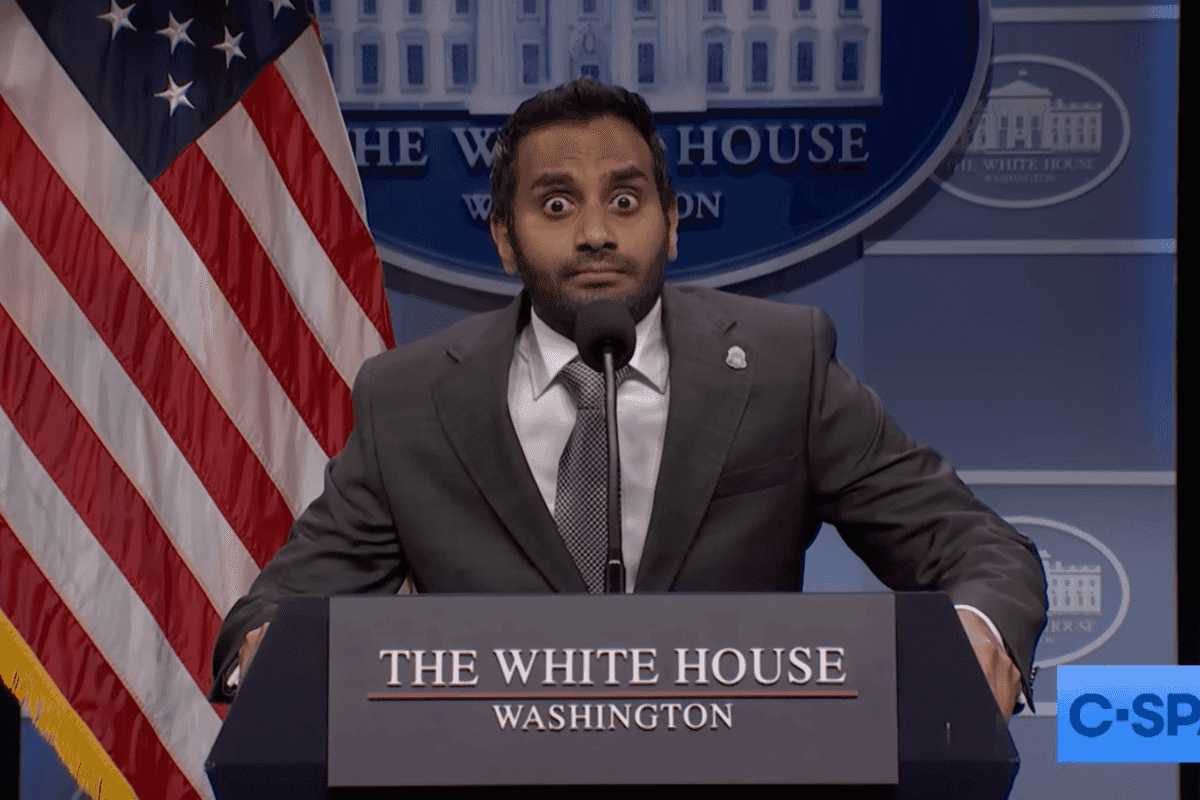 Aziz Ansari as Kash Patel on Saturday Night Live, staring with bulging eyes behind a White House lectern.