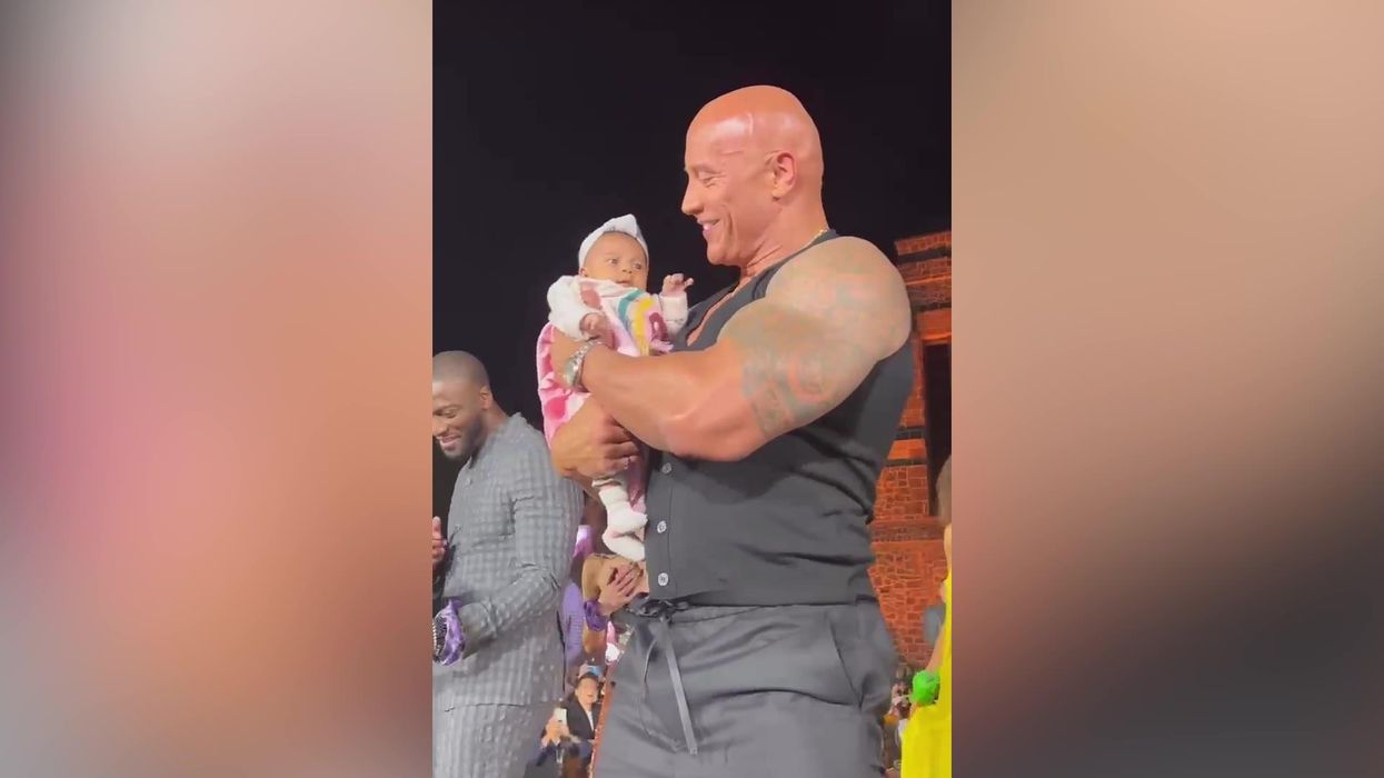 Wild video sees audience 'crowd surf' a baby into The Rock's arms