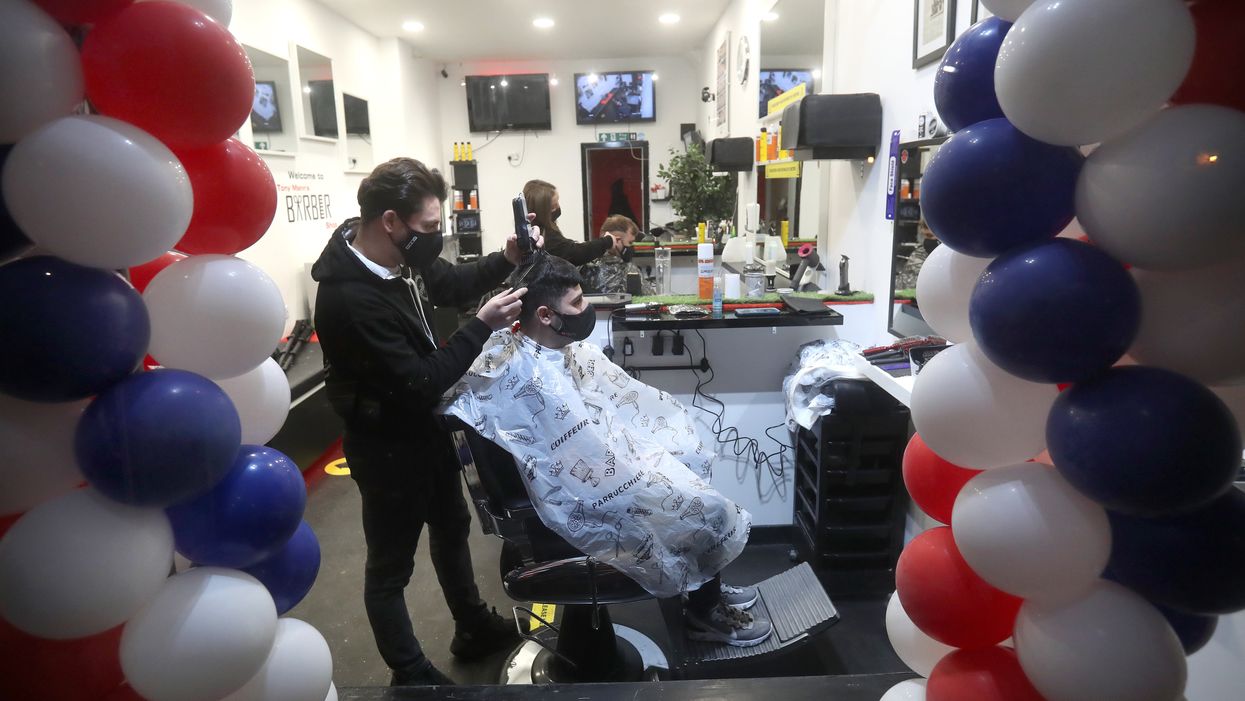 Barber Tony Mann trims Maxx Mann’s hair at Tony Mann’s Barber Shop in Giffnock near Glasgow
