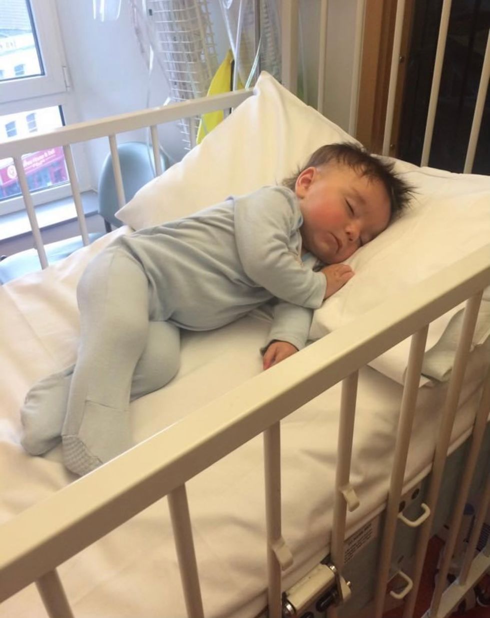 Barney as a baby lying in a cot