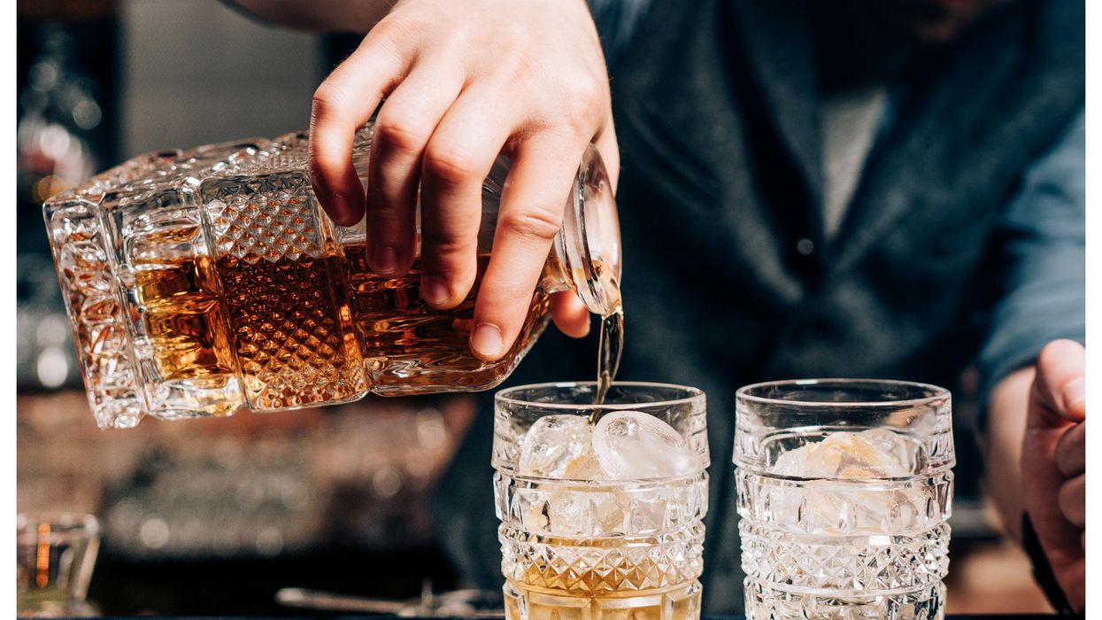 Bartender pouring whiskey over ice