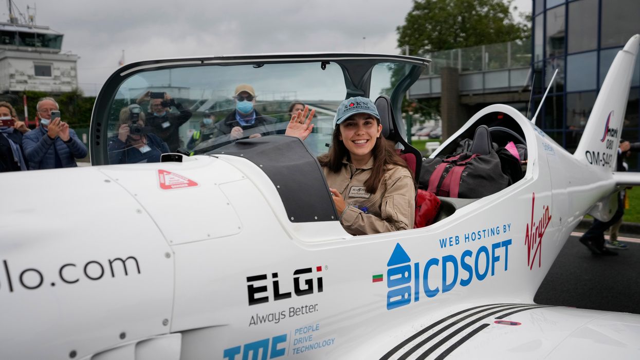 Belgian-British teenager Zara Rutherford waves from her Shark Ultralight plane prior to take-off at the Kortrijk-Wevelgem airfield in Wevelgem, Belgium (Virginia Mayo/AP)