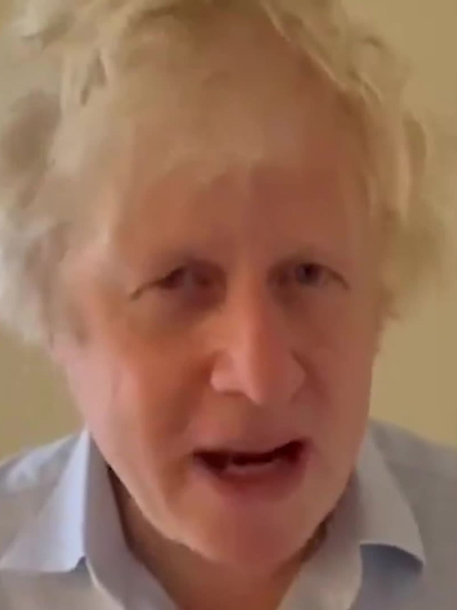 Boris Johnson, a white man with a light blue collared shirt and scruffy blonde hair.
