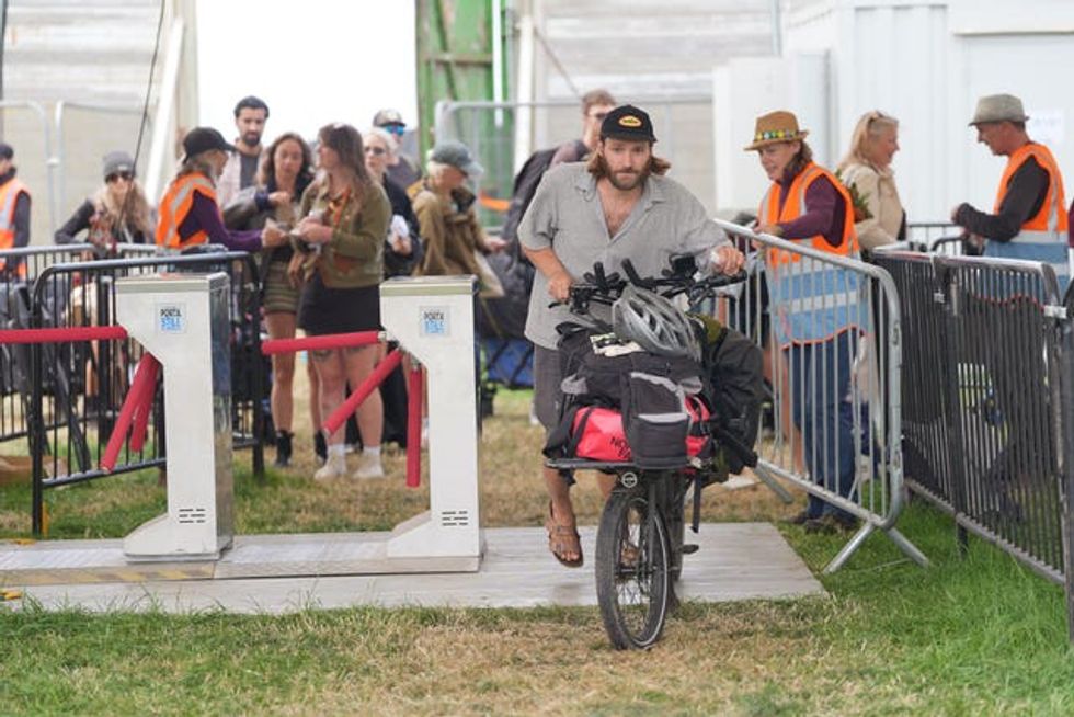 British singer-songwriter Jack Cullen arrives on a bike at Glastonbury Festival