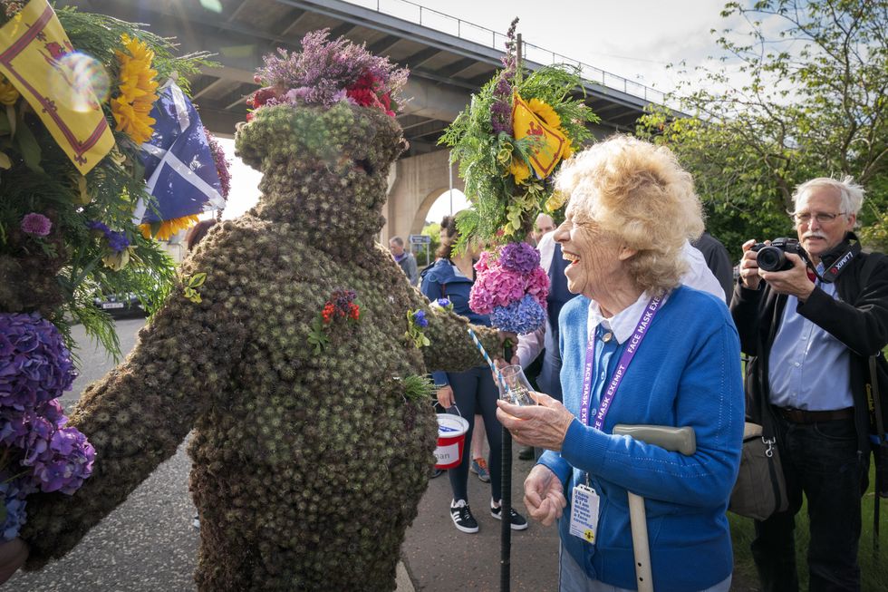 Burryman Andrew Taylor gets a nip of whisky using a straw from resident Kathleen Hamblin (Jane Barlow/PA)