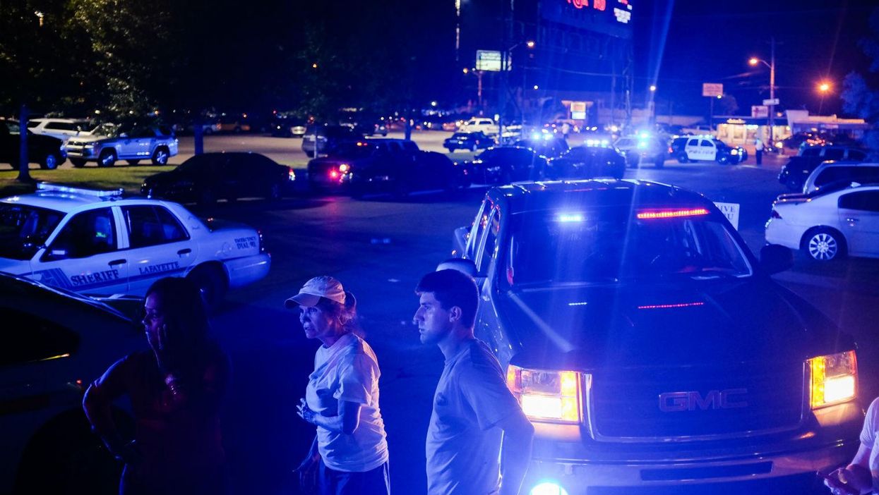 Bystanders look on at the scene of a deadly shooting in Lafayette, Louisiana on Thursday night