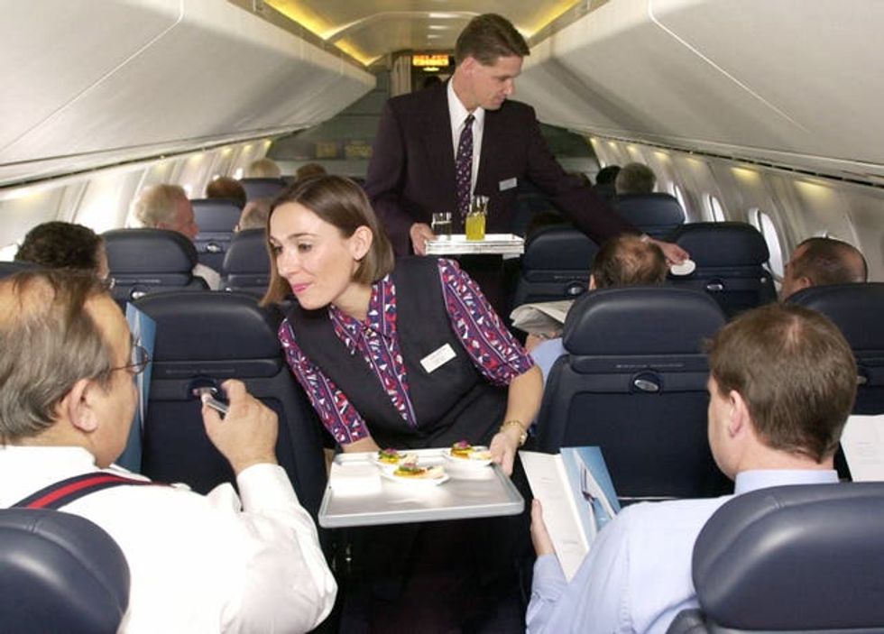 Cabin crew serve refreshments to passengers on board a British Airways Concorde