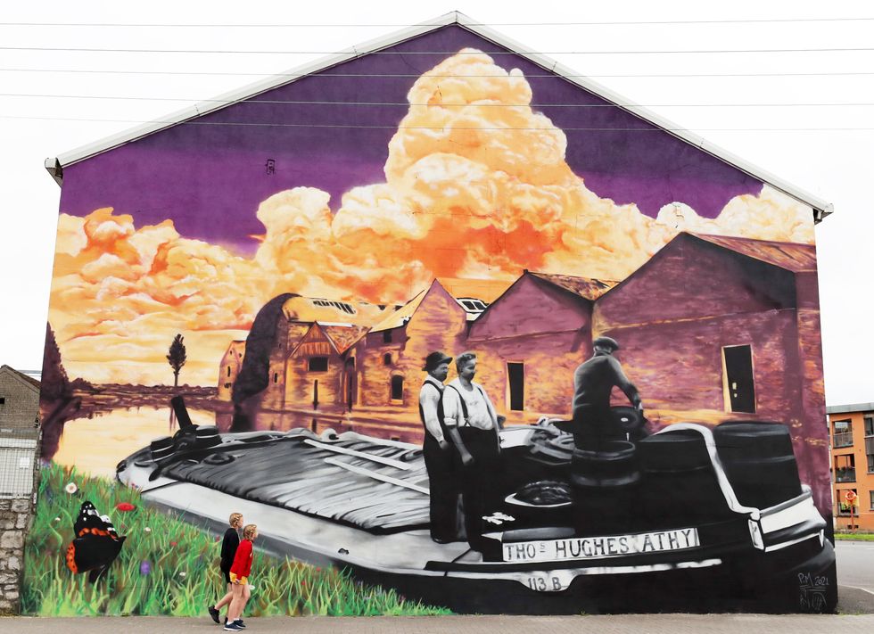 Caitlin and Caoimhe Owens, who are children of a deaf adult, admire Peter Martin\u2019s new mural in Athy, Co Kildare (Niall Carson/PA)