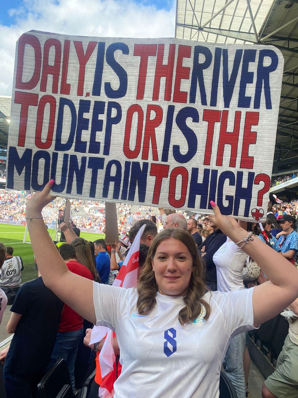 Caitlin Greshon at a football match holding up a sign