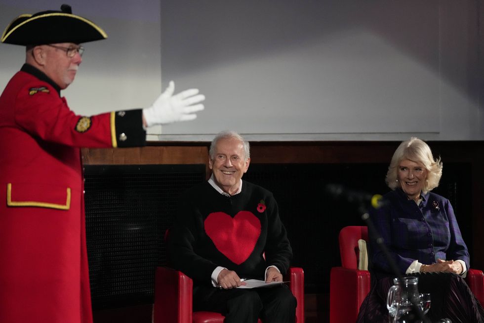 Camilla and Poetry Together founder Gyles Brandreth, centre, watch Chelsea Pensioner Roy Palmer recite a poem about the climate crisis (Frank Augstein/PA)