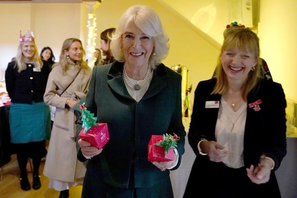 Camilla holding boxes containing Christmas puddings