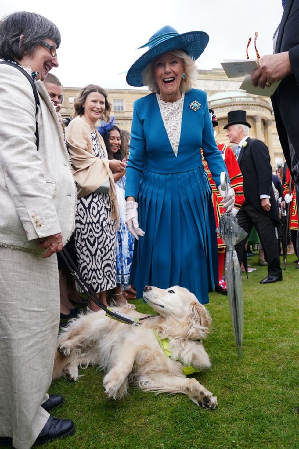 Camilla next to a dog at the palace party