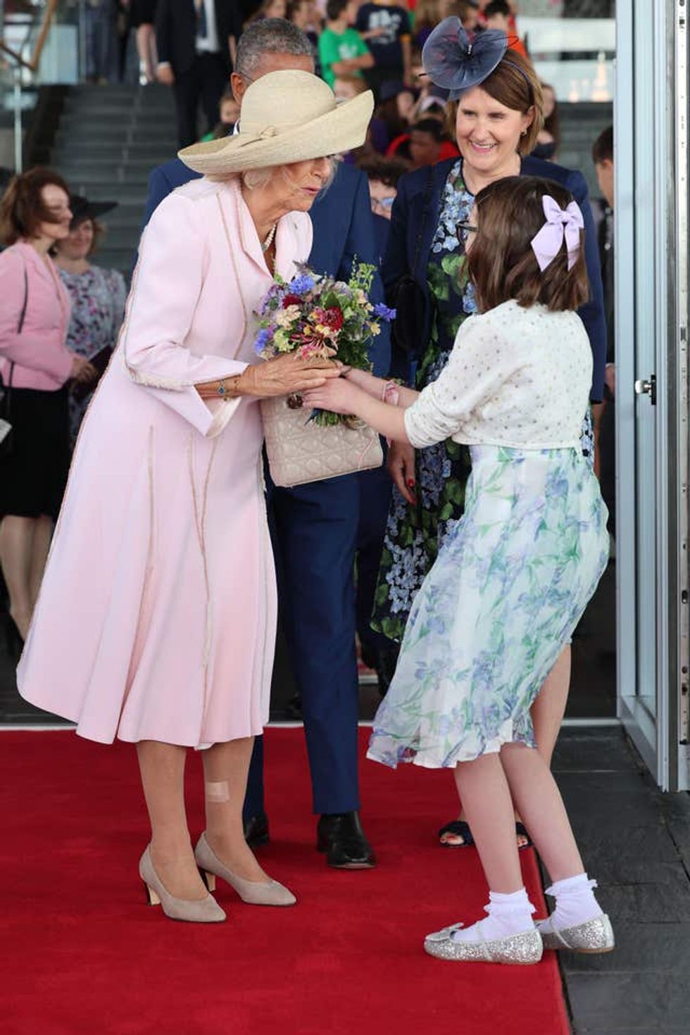 Camilla receives a bouquet of flowers from a young girl