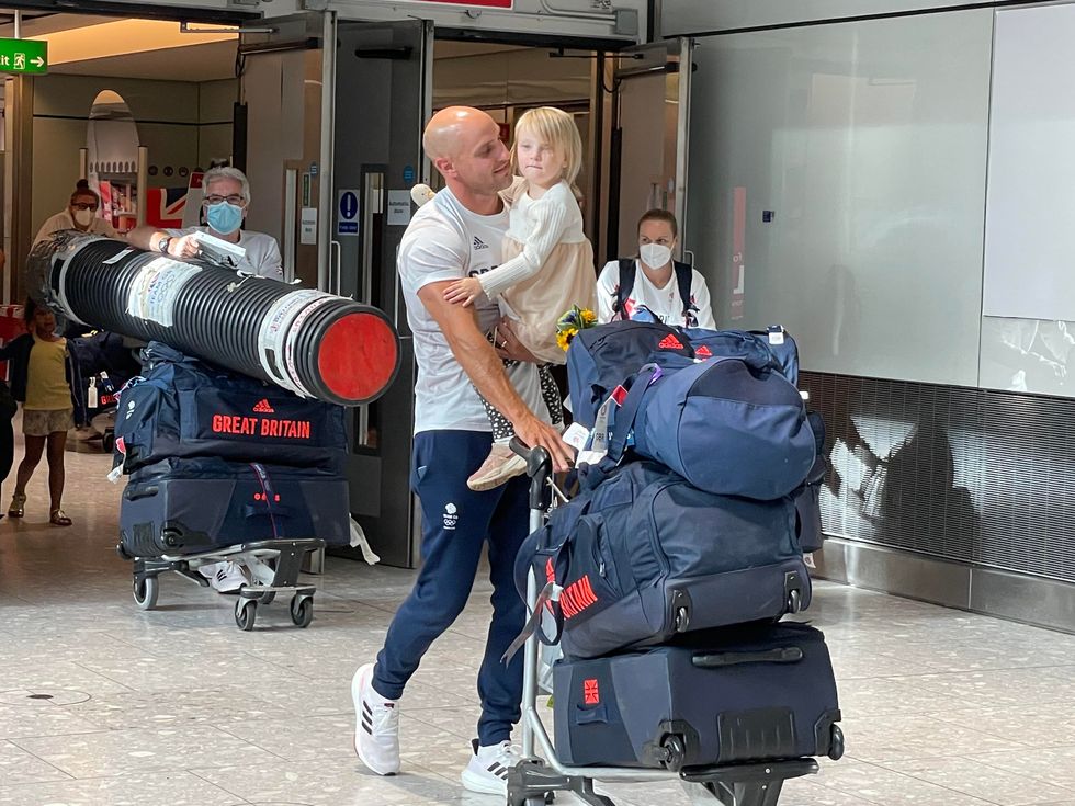 Canoeist Liam Heath is reunited with his three-year-old daughter Sarah at Heathrow Airport (Elmira Tanatarova/PA)