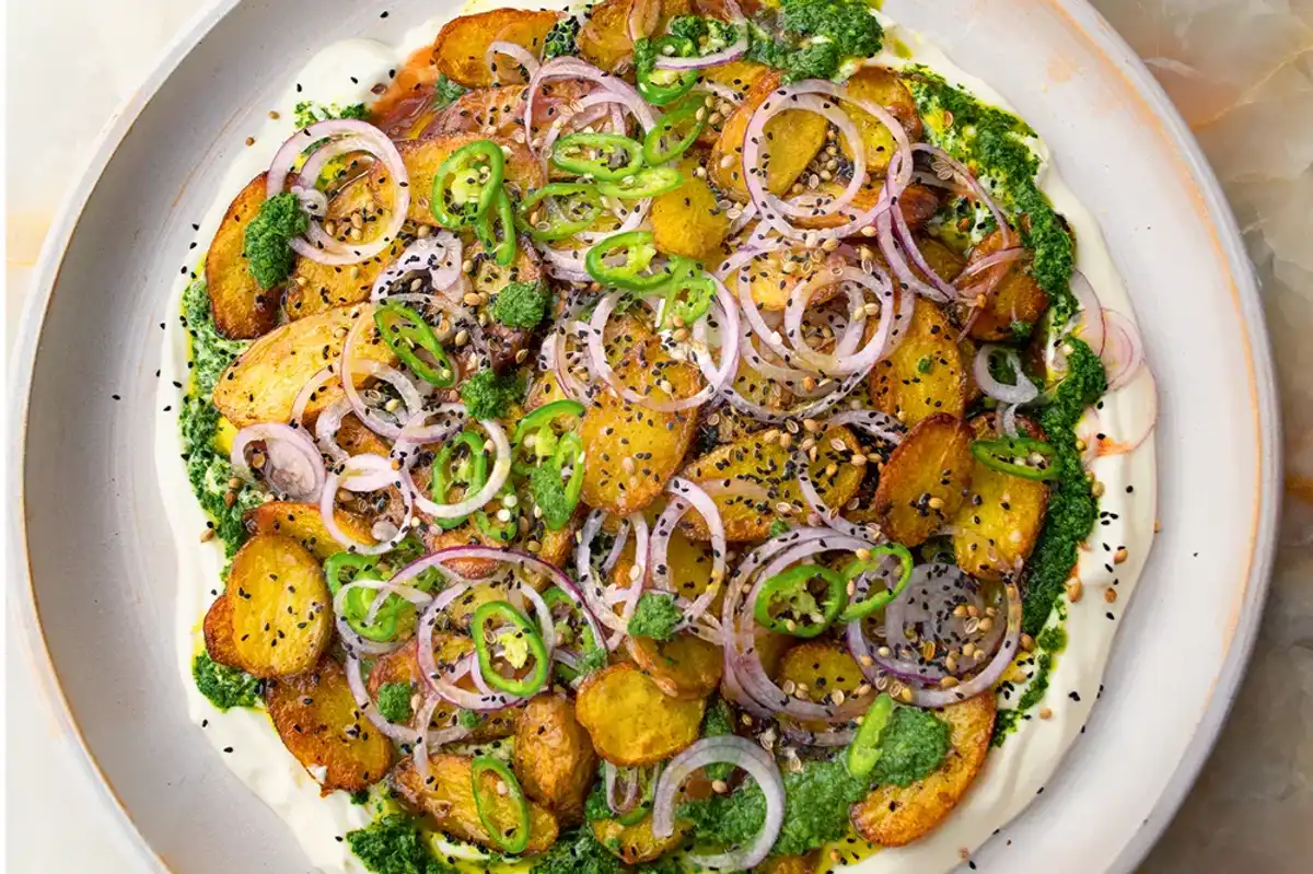 Chaat masala potatoes with yoghurt presented on a white plate