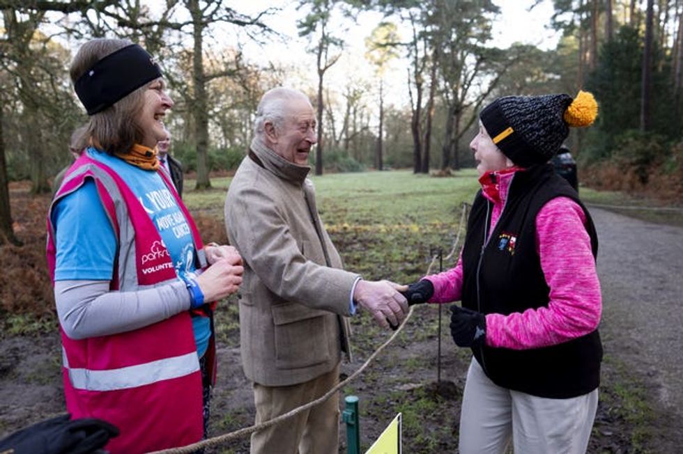 Charles and volunteer Sarah Byatt at a marshal point speak to participants in the Sandringham parkrun