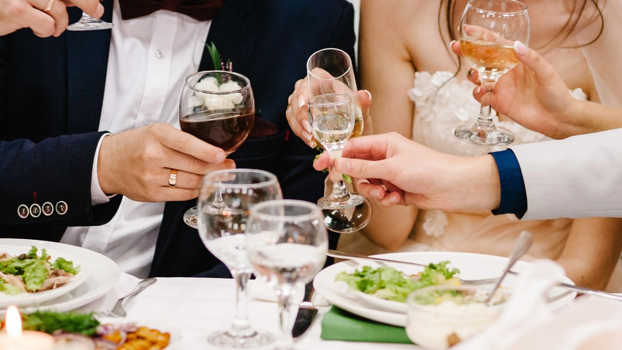 <p>Cheers! Newlyweds with friends drink champagne celebrate at the table. People raise glasses of wine and vodka for toast. Group of men and women celebrate wedding.</p>