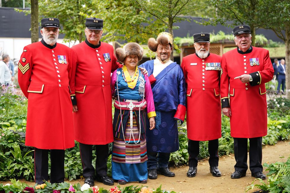 Chelsea Pensioners pose with guests from Tibet wearing traditional costume (Yui Mok/PA)
