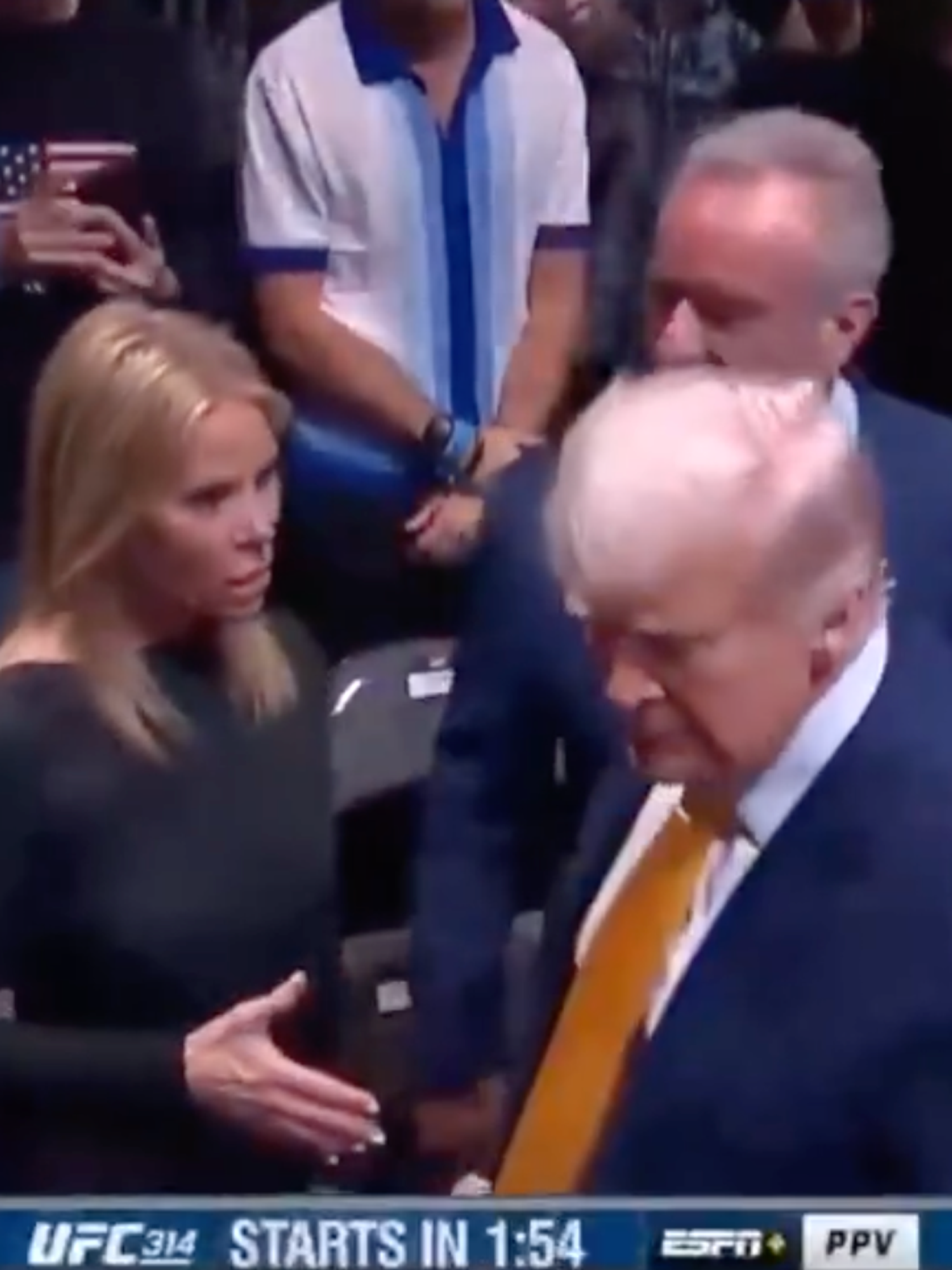 Cheryl Hines frowns as Donald Trump turns away from her outstretched hand at a UFC event.