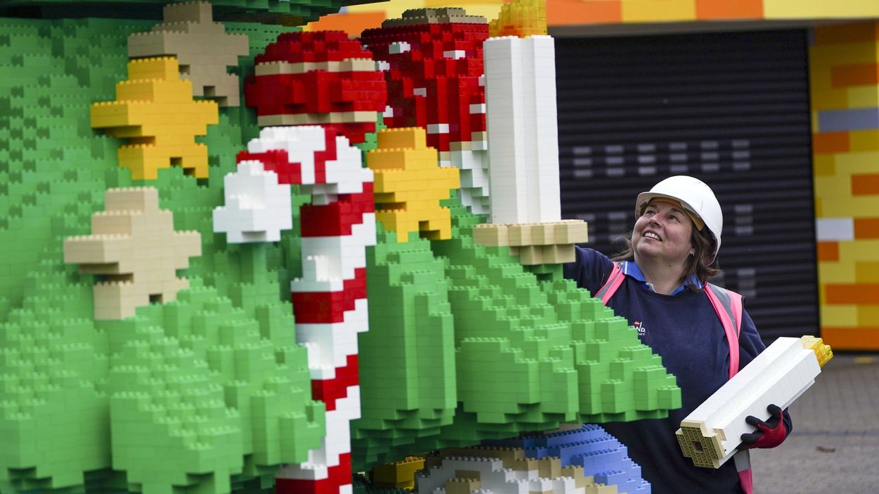 Chief model maker Paula Laughton puts the finishing touches to a 33ft tall Lego Christmas tree (Steve Parsons/PA)