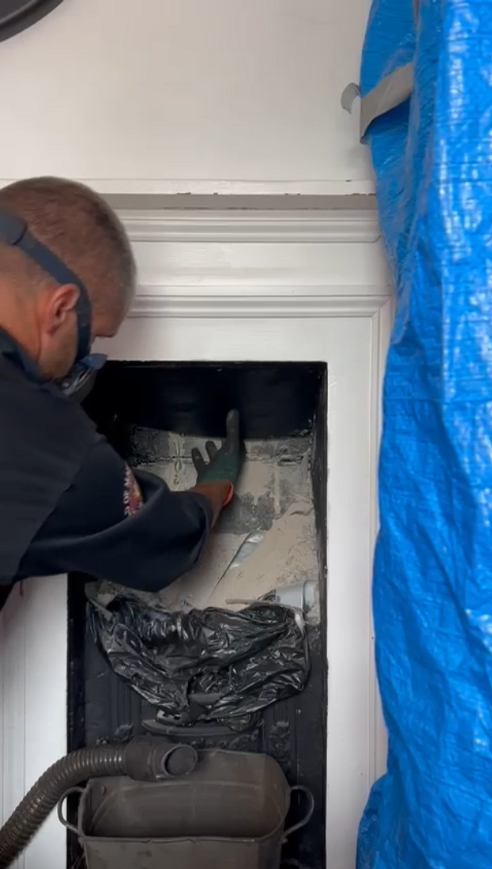 Chimney sweeps reaches for board inside flue