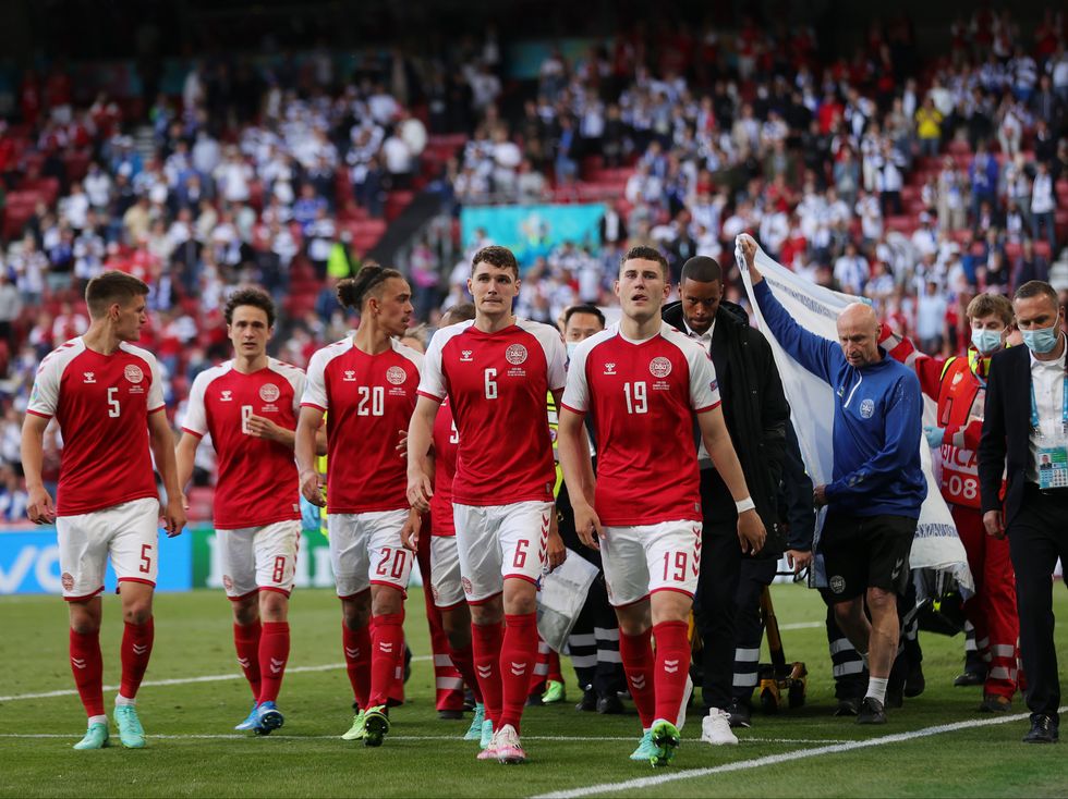 <p>Christian Eriksen is escorted off of the field by team mates and medics on a stretcher</p>