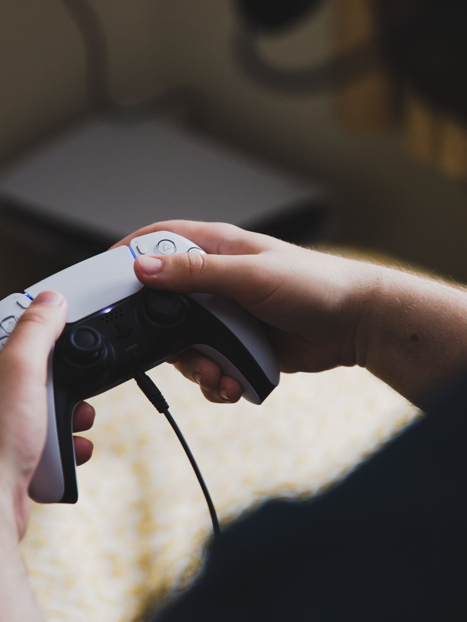 Close up of a pair of hands holding a PlayStation 5 video game controller stock photo