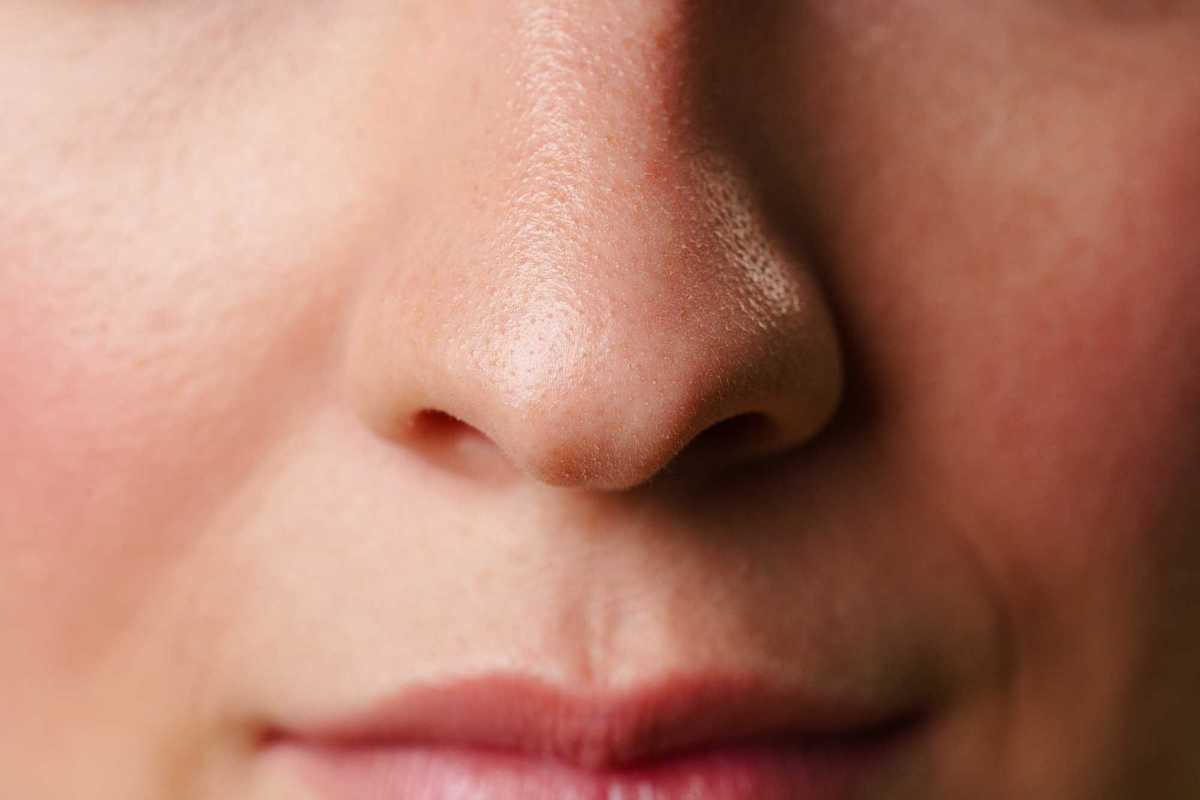 Close-up of a woman's lips and nose with a neutral expression.