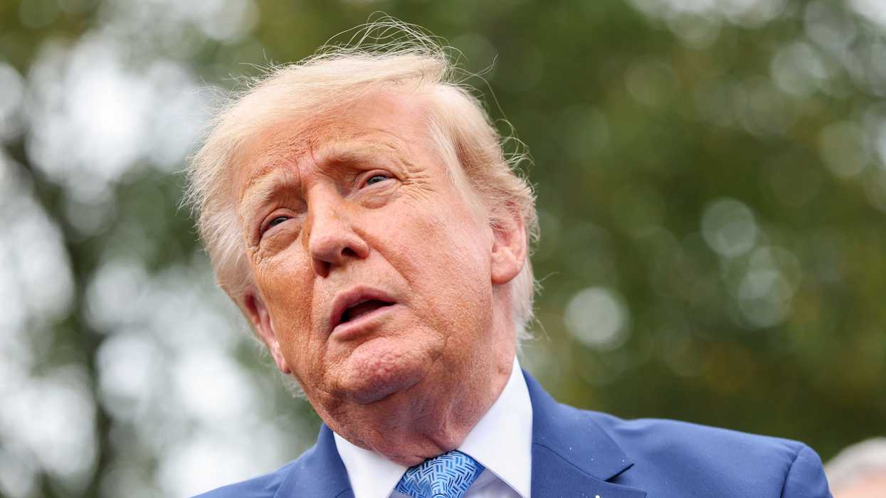 Close up of Donald Trump in a blue suit talking to reporters outside the White House.