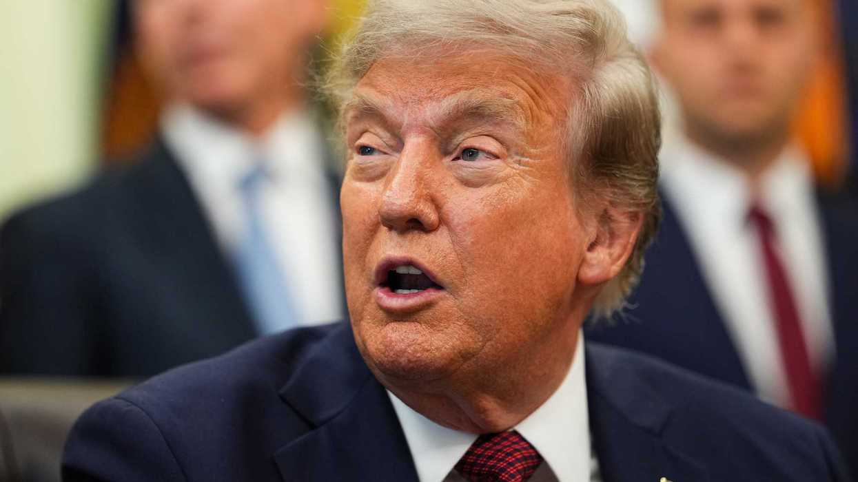 Close-up of Donald Trump looking to his right and speaking to reporters in the Oval Office.