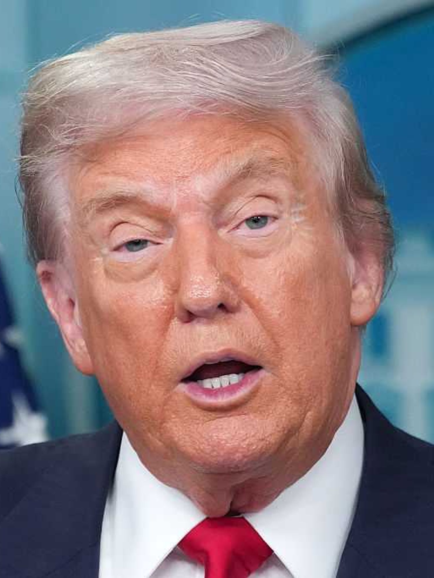 Close-up of Donald Trump speaking during a press briefing.