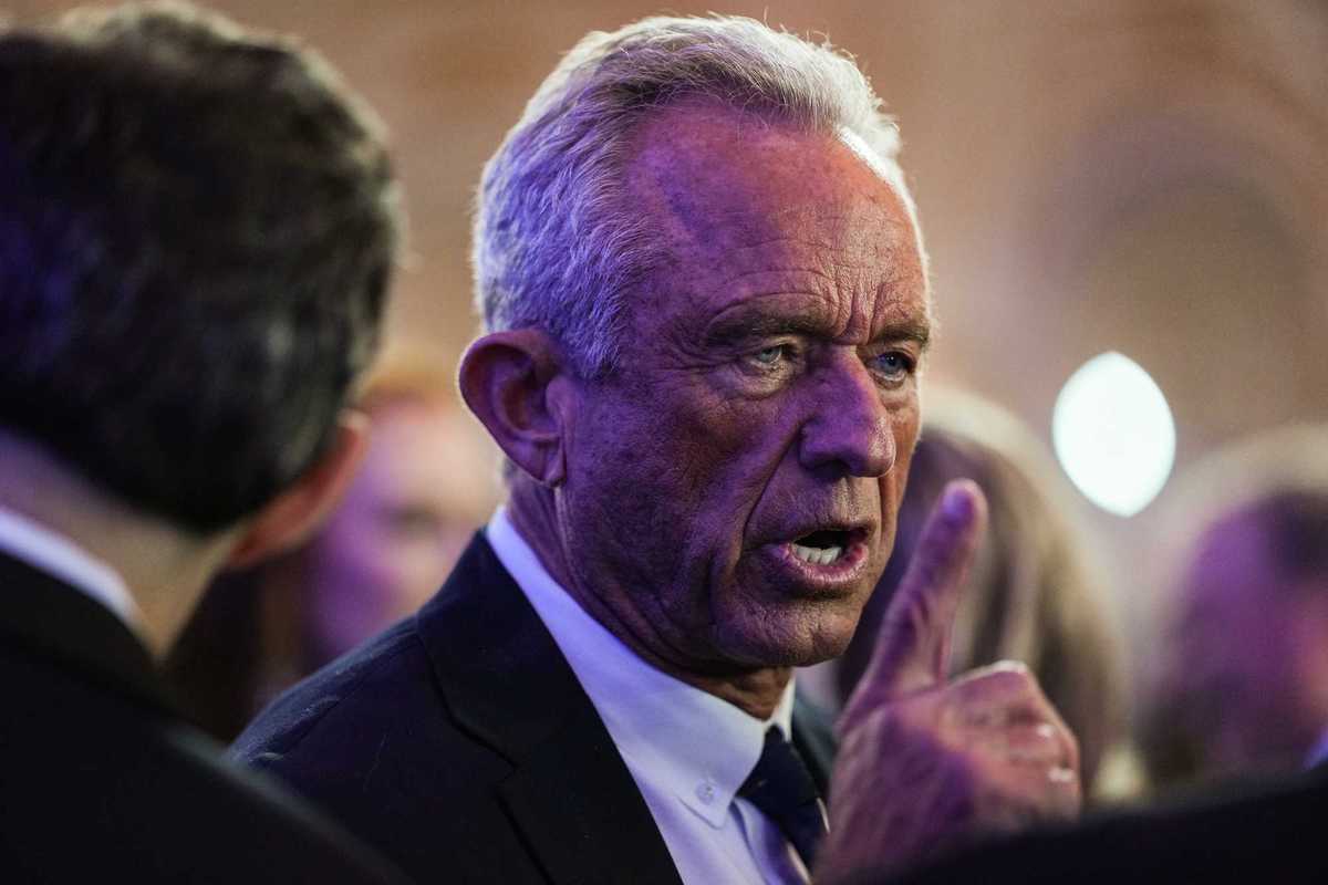 Close up of Robert F. Kennedy Jr talking to people at the White House Correspondents' Dinner. He has his right index finger raised.