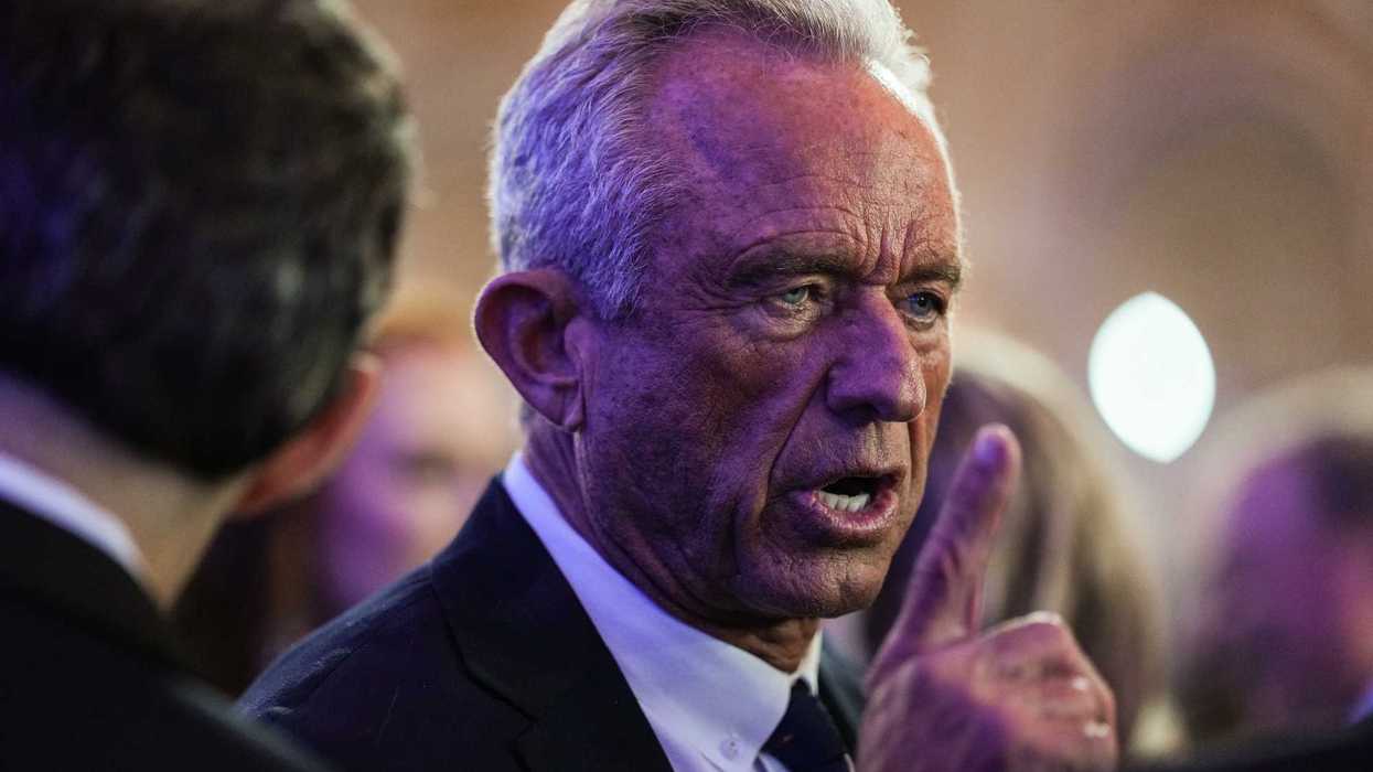 Close up of Robert F. Kennedy Jr talking to people at the White House Correspondents' Dinner. He has his right index finger raised.