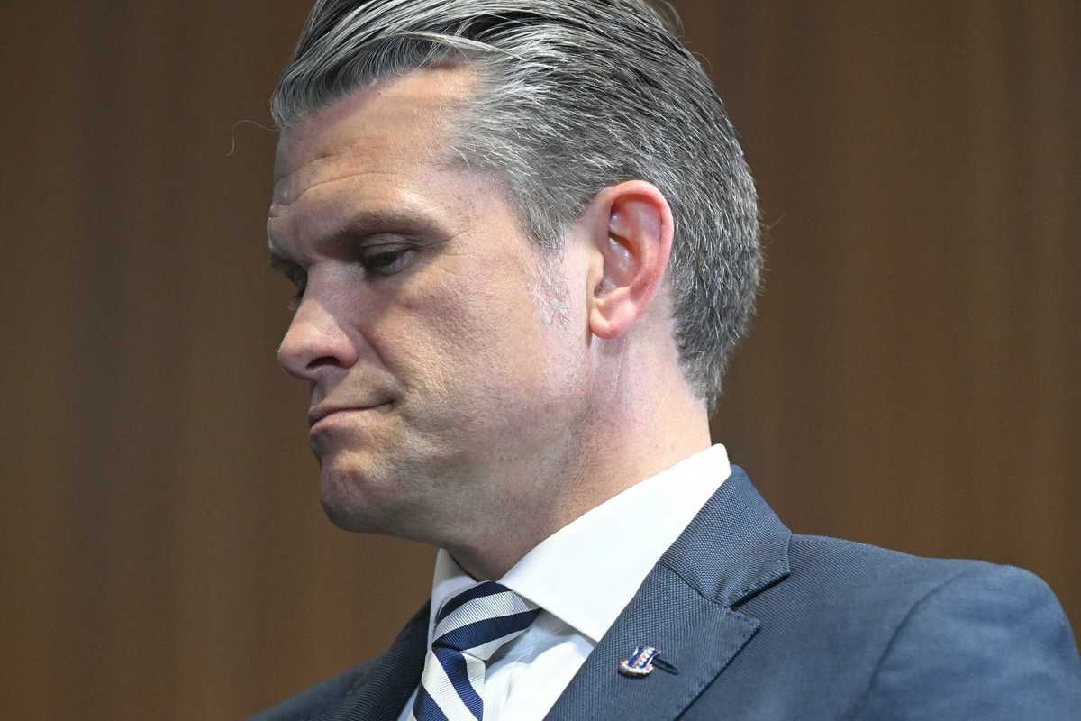 Close-up photo of Pete Hegseth, a white man with short grey hair and a blue suit.