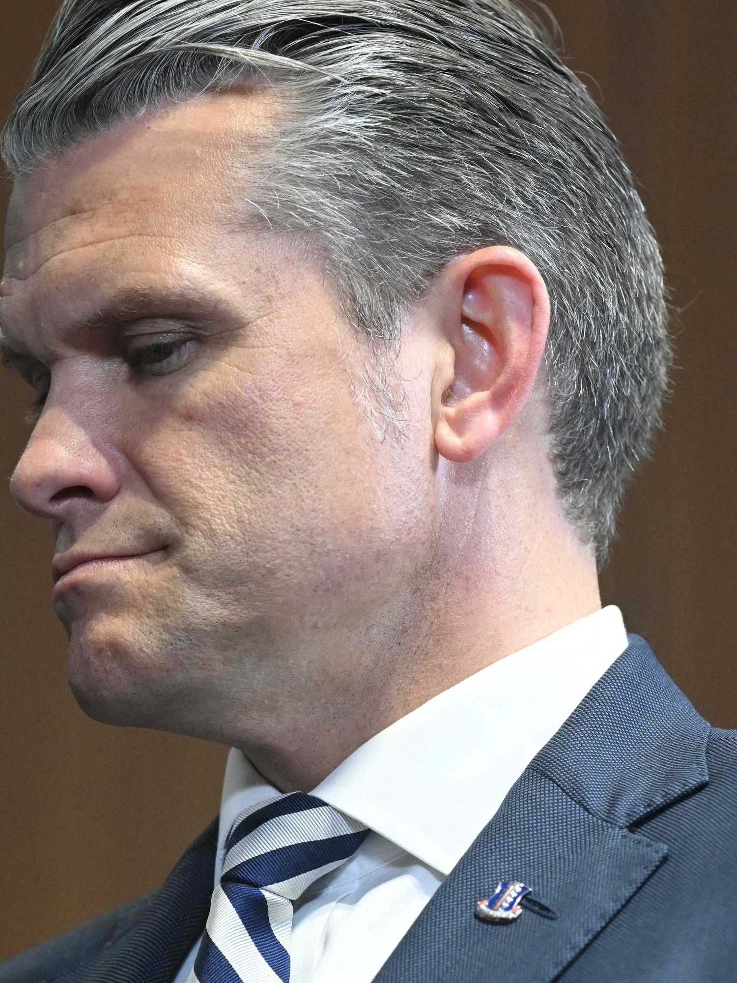 Close-up photo of Pete Hegseth, a white man with short grey hair and a blue suit.