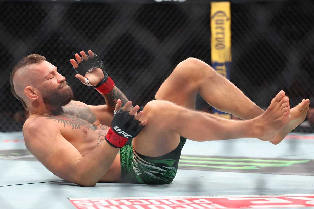 Conor McGregor of Ireland falls after sustaining an injury on a kick in the first around against Max Holloway of the United States in their welterweight bout during UFC 329 at T-Mobile Arena on July 11, 2026 in Las Vegas, Nevada