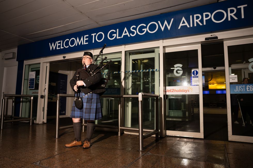 Craig Ferguson was piped into the Glasgow Airport terminal piped into the terminal by Bagpipe Players Scotland (Francesca Morrison/PA)